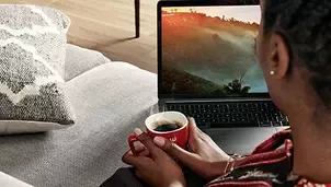 Devojka pije Nescafédok radi na njenom laptopu